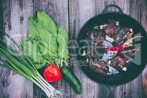 Fried pork ribs with a black frying pan