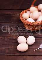 Fresh chicken eggs on a brown wooden surface