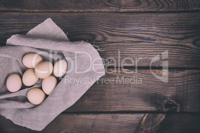 Fresh chicken eggs in shell lie on cloth gray napkin