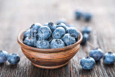 Fresh Blueberry in bowl on wooden background, closeup