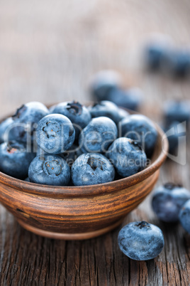 Fresh Blueberry in bowl on wooden background, closeup