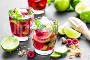 Raspberry mojito cocktail with lime, mint and ice, cold, iced refreshing drink or beverage