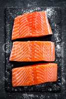 Raw salmon filet on dark slate background, wild atlantic fish
