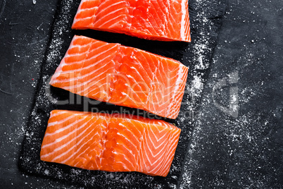 Raw salmon filet on dark slate background, wild atlantic fish