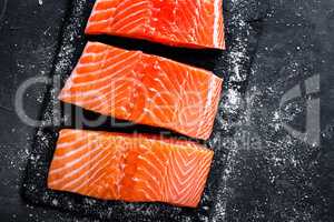 Raw salmon filet on dark slate background, wild atlantic fish