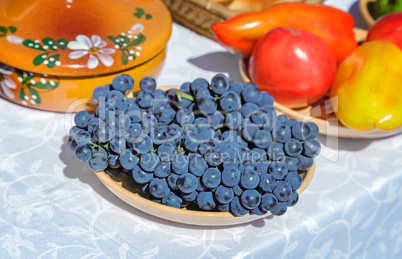Still life: grapes on a plate on a white tablecloth table.
