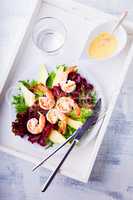 Avocado shrimp salad with mustard sauce on a tray