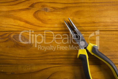 multitool pliers on wooden background