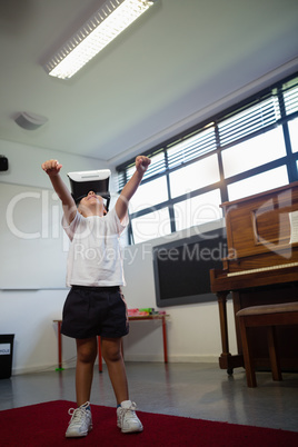 Low angel view of boy wearing virtual reality simulator gesturing