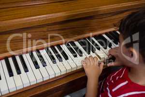 Close up of boy playing piano in classroom