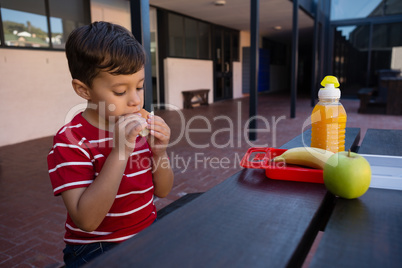 Close up of boy eating while sitting by table