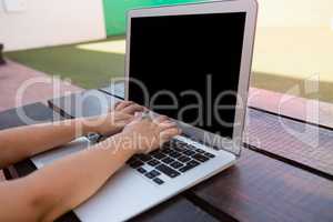 Close up of boy using digital laptop while sitting at table