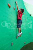 Side view of boy climbing wall at playground