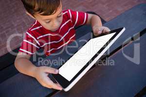 High angle view of boy using tablet while sitting at table