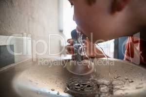 Close up of boy driniking water from faucet
