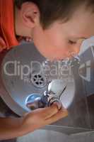 High angle view of boy driniking water from faucet