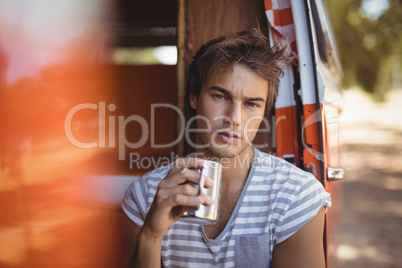 Portrait of man drinking coffee while sitting in van