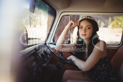 Portrait of beautiful woman leaning on steering wheel