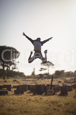 Man jumping on field against clear sky