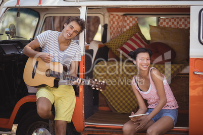 Portrait of happy friends enjoying while sitting in motor home