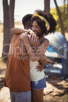 Side view of couple embracing while standing against tent