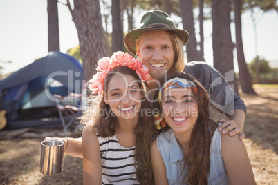 Portrait of smiling friends against tent camping at forest