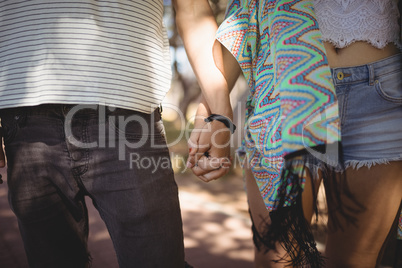 Midsection of couple holding hands