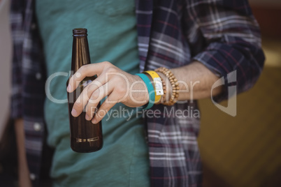 Midsection of man holding beer bottle