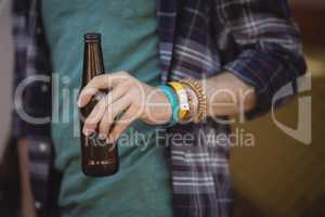 Midsection of man holding beer bottle