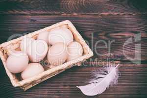 Fresh raw eggs in a wicker basket