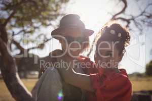 Portrait of happy young couple embracing on field