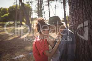 Happy young couple standing face to face at forest