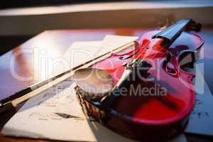 Close up of violin with sheet music on table