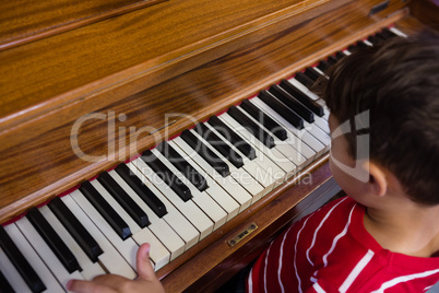 High angle view of boy playing piano in classroom