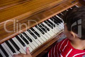 High angle view of boy playing piano in classroom
