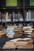 Close up of books stack on table against shelf
