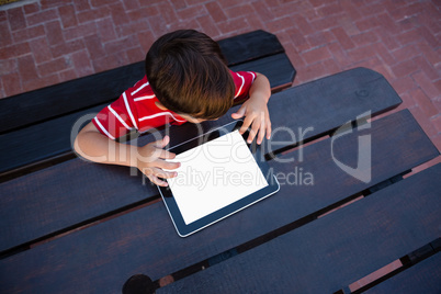 Directly above shot of boy using digital tablet while sitting at table
