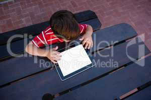 Directly above shot of boy using digital tablet while sitting at table