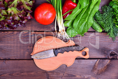 Fresh vegetables and a cutting board with a knife