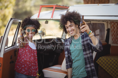 Portrait of cheerful friends holding beer bottles