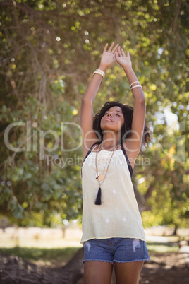 Young woman stretching while standing on field