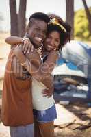 Side view portrait of smiling couple standing against tent