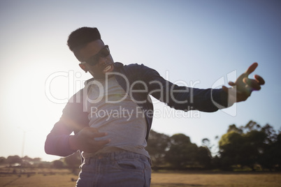 Close up of man gesturing while standing on field