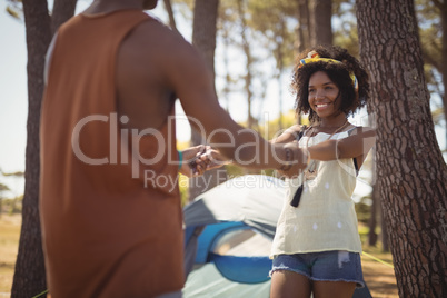 Happy couple holding hands while standing against tent