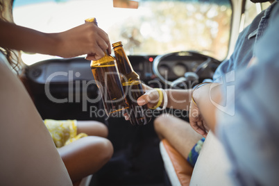 Midsection of friends toasting beer