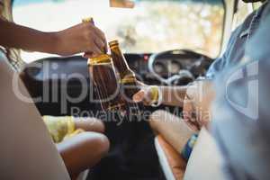 Midsection of friends toasting beer