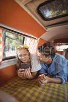 Happy woman with man using phone in van