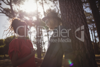 Low angle view of happy young couple looking at each other while standing together at forest