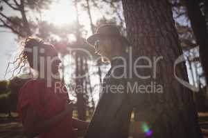 Low angle view of happy young couple looking at each other while standing together at forest