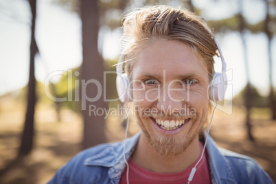 Close up of smiling man listening music on headphone